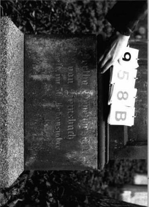 Grabstein 958 (Index: 99802656) Material: Sandstein Zustand: leicht verwittert Maße HxBxT: 210x57x45 cm Beschreibung: mehrfach getreppter Sockel, Stele mit verdachtem Giebel Symbolik: Inschriftenfeld mit gotisierendem Maßwerk: Grabstein 958B