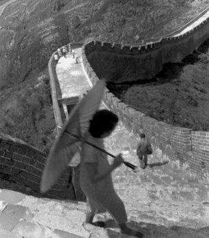 Touristen und Sonnenschirm auf der Chinesischen Mauer mit Blick in die Berglandschaft