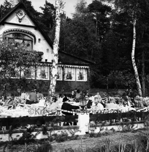 Lütjensee: Restaurant Forsthaus Seebergen: vorn Terrasse mit Gästen an Tischen