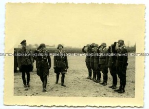 Offiziere schreiten eine Front angetretener Soldaten ab