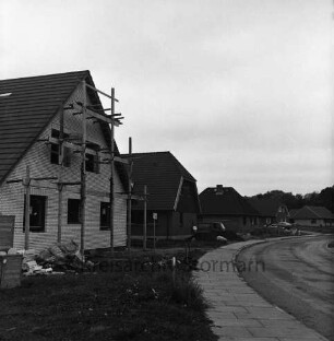 Oetjendorfer Kirchenweg: Neubaugebiet mit Eigenheimen: vorn links Rohbau mit Gerüst: davor Baumaterial: hinten Mitte und rechts Häuser vor und nach Fertigstellung: davor Lieferwagen und Pkw