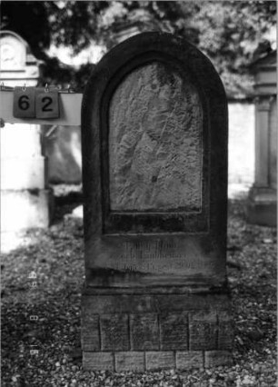 Grabstein 62 (Index: 100086515) Material: Sandstein Zustand: Inschriftenplatte fehlt Maße HxBxT: 123x51x15 cm Beschreibung: Stele, Sockel, Spitzbogenabschluß: Grabstein 62