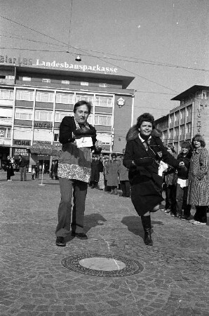 Deutsch-englischer Freundeskreis Karlsruhe. Pfannkuchen-Rennen "pan-cake-race" am schmutzigen Donnerstag auf dem Karlsruher Marktplatz