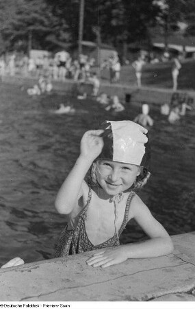 Porträt eines kleinen Mädchens in Badebekleidung am Beckenrand im Freibad