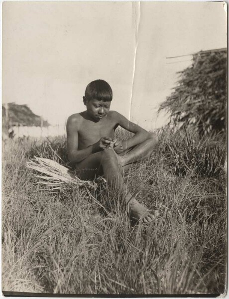 Un Indien patamona nettoie la plante de ses pieds des puces de sable