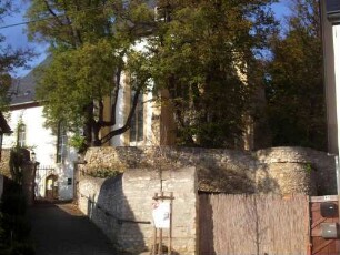 Ansicht von Südosten mit Kirche über Kirchhofmauer und flankierendem Schalenturm (Wehrgang im 18 Jh abgetragen) sowie ehemaligem Zwingeraufgang vom Ort (Toranlagen im 18 Jh abgetragen)