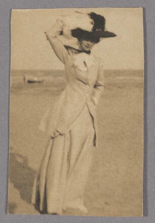 Junge Dame mit großem Hut am Strand, en face
