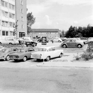 Erweiterungsbau "Hochhaus" [später Gebäude B]: III. Bauabschnitt: Parkplatz vor fertiggestelltem Gebäude mit Pkws: hinten Mitte Erweiterungsbau II. Bauabschnitt