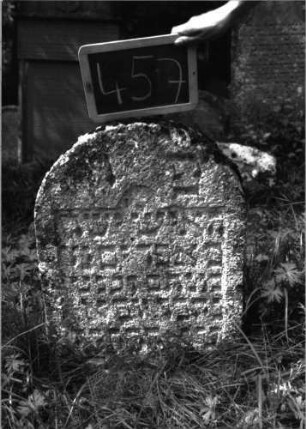 Grabstein 457 (Index: 100102709) Material: Sandstein Zustand: leicht verwittert, eingesunken, teilweiser Textverlust Maße HxBxT: 73x50x10 cm Beschreibung: Stele, Rundbogenabschluss, Schriftfeld eingetieft mit eingezogenem Rundbogenabschluss Besonderheit: kulturhistorisch wertvoll / hist.-wiss. Gründe (Alter): Grabstein 457