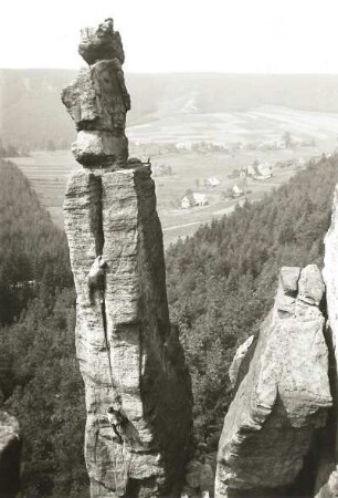 Böhmische Schweiz (České Švýcarsko), Eiland (Ostrov). Empornadel (Vztyčená jehla). Seilschaft Ehrhardt Renger im Riß des Ostweges. Blick nach Nordwest gegen Eiland (Ostrov) und Grenzplatte