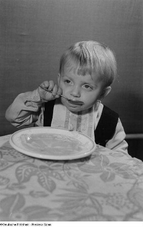 Ein Kind beim Verzehr von Nudelsuppe