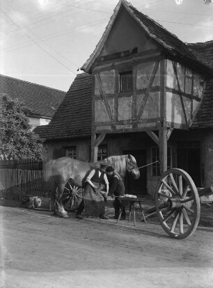 Dorfschmiede : Dorfschmiede. Hufschmiede beim Beschlagen der Hufe