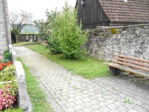 Kirchhof im Osten mit Kirchhofmauer (Wehrgang mit Steinbrüstung und Schießscharten im 19 Jh abgetragen) im Verlauf