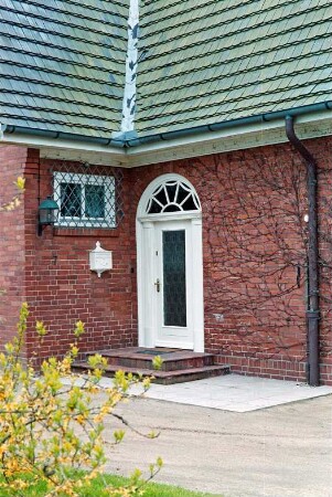 An den Stücken (7): Wohnhaus aus Backstein: Traufseite, Teilansicht mit Eingangstür: links Querbau