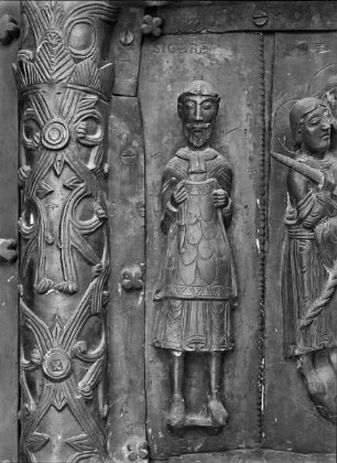 Bronzetür — Rechter Flügel mit Darstellungen zur Passion Christi — 2. Reihe von oben: Einzug in Jerusalem und verschiedene Figuren — Mann mit ausgezogenem Rock