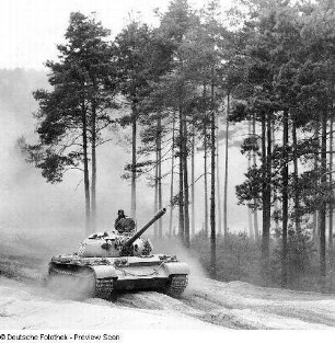 Deutschland . Nationale Volksarmee - Landstreitkräfte. Kampfpanzer in Fahrt auf einem Waldweg