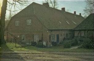 Altfresenburg 15: traufständige Landarbeiter-Mehrfamilienkate, Backsteinmauerwerk: Giebelseite und rückwärtige Traufseite mit Türen: rechts Querbau aus Fachwerk