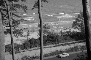 Timmendorfer Strand: Blick von oben auf den Strand, Vordergrund Bäume, unten Bäderstraße
