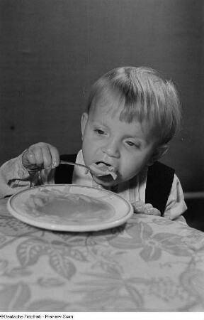 Ein Kind beim Verzehr von Nudelsuppe