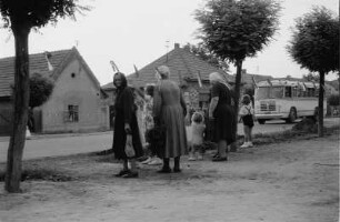 Einheimische am Straßenrand eines Ortes mit Omnibus