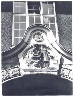 Schule am Wall: Relief über dem Eingang. Detmold. Über dem Baujahr und der Skulptur von Lehrerin und Schülerin das Wappen der Stadt Detmold. aus DT S 8 (Stadtgymnasium) Nr. 260. sw-Papierabzug