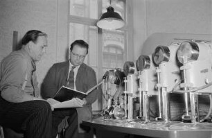 Erfurt. Handwerksproduktionsgenosenschaft der Erfurter Konfektionswerkstätten "August Bebel". Werkstattraum, zwei leitende Mitarbeiter im Gespräch