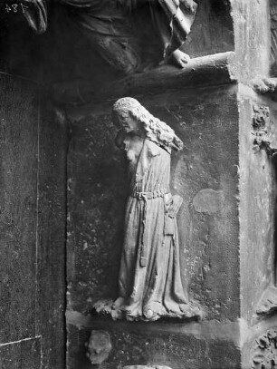 Südliches Westportal — Südlicher Türpfosten — Weibliche Gestalt mit halbentblößter Brust, Unkeuschheit (?) (i 7)
