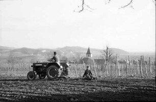 Burkheim: Traktor mit Egge, Hintergrund Ort