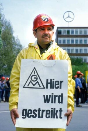 Arbeiter demonstriert für die 35-Stunden-Woche vor dem Mercedes-Firmengebäude in Stuttgart