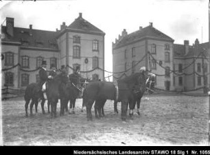 Dressur- und Reitschule in der Artilleriekaserne Wolfenbüttel, Lindener Straße Enthält: Vier Reiter im Reitdress mit Zylinder halten zwei Pferde am langen Zügel