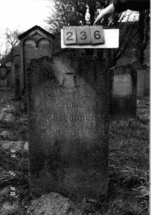 Grabstein 236 (Index: 99798715) Material: Kunststein Zustand: leicht verwittert Maße HxBxT: 97x50x15 cm Beschreibung: Stele mit mehrfach eingezogenem Bogenabschluß Symbolik: Kanne in Schale: Grabstein 236