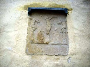 Langhaus Traufseite Nord im Nordwesten - eingemauerte Grabplatte mit Figuren in Hochrelieftechnik - Textkartsuche verwittert - von Vorgängerkirche übernommen