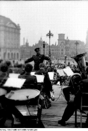 Dresden. 750-Jahr-Feier Dresden, u.a. festliche geschmückte Häuser, Fahnenschmuck auf dem Theaterplatz, Auslage des Café Toscana am Schillerplatz, Platz der Einheit (Albertplatz), Hotelportiers, Andenken, Fahrradtouristen, Richtfest, Modenschau, fahrbahres Postamt, Konzert auf dem Altmarkt, Verkehrsschilder, Juni 1956