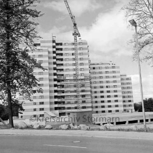 Hochhaus-Wohnanlage Neuhöfer Teich: Fertigstellung: Abbau der Gerüste, Baukran: im Vordergrund Mahlmannstraße, links Baum, rechts Straßenlampe, Feldsteine