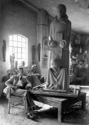 Magdeburger Ehrenmal : Güstrow, Walkmühlenstraße. Atelier Ernst Barlachs. Der Bildhauer Bernhard A. Böhmer (Gehilfe Barlachs) mit der Mittelgruppe des Magdeburger Ehrenmals. Eichenholz, geschnitzt (1929; E. Barlach)
