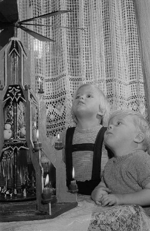 Zwei Kinder vor einer Weihnachtspyramide