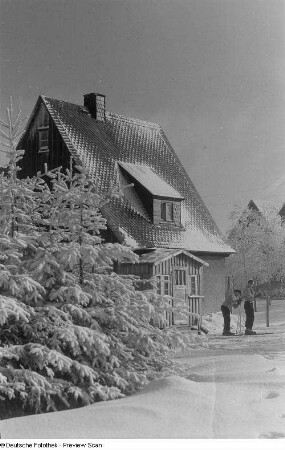 Schneelandschaft mit Häusern und zwei Skifahrern