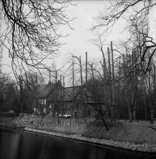 Schlossmühle: davor Mühlenredder, Mühlenbrücke: Alleebäume mit frischem Schnitt: Autos: vorne Schlossgraben, Uferbefestigung mit Findlingen