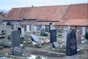 Friedhof, dahinter durchgehende Reihe von Dächern