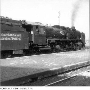 Eingefahrener Zug an einem Bahnsteig. Blick gegen Dampflokomotive 39 211
