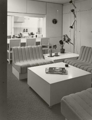Couchtisch : Musterwohnung (1972; Deutsche Bauakademie). Blick von der Sitzgruppe im Wohnzimmer über den in die Anbaumöbel integrierten Eßplatz zur Kochecke