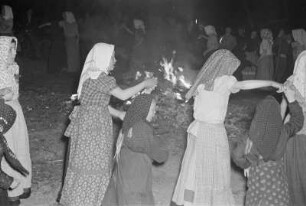 Kinder tanzen um das Hexenfeuer in Ostro : Chodojtypalenje we Wotrowje. Dźěći rejuja wokoło wohenja : Ostro / Wotrow