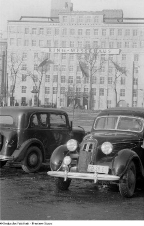Zwei parkende Autos vor dem Ringmessehaus (BMW 321 oder BMW 326) vor dem Ring-messehaus