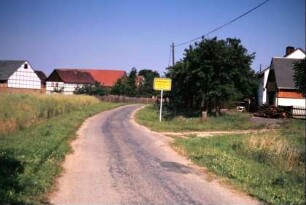 Ortseingang mit Ortsschild, Häuser