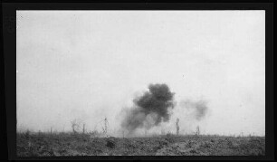 Sailly-Saillisel (Dep. Somme, Frankreich): weites zerfurchtes Feld mit Rauchschwaden (Distanzaufnahme) ("Einschlag eines 30 cm-Geschosses. 1916")