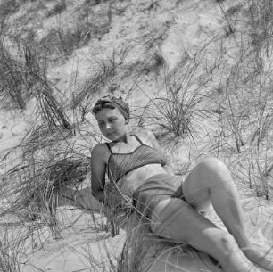 Elisabeth Gremmler liegt auf einer Düne umgeben von Strandhafer