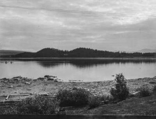 Seeblick : Blick über einen See in Skandinavien, im Hintergrund bewaldete Landschaft auf