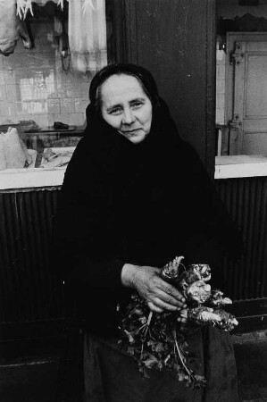 Alte Frau mit Wurzelgemüse