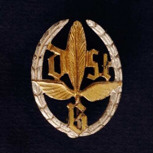 Treueabzeichen in Silber Deutscher Stenografenbund (mit Broschennadel) : Medaillensammlung Stenografische Sammlung. Treueabzeichen in Silber Deutscher Stenografenbund ("DStB" mit geflügelter Feder im Lorbeerkranz, mit Broschennadel). Metall, versilbert; Maße 21 x 16 mm (nach 1960). Dresden: SLUB R c 0460