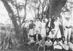Gruppenbild einer Jagdgruppe mit Ernst Otto Gerhardt und einheimischen Jagdhelfern sowie Begleittross am Lagerfeuer, aufgenommen in Argentinien